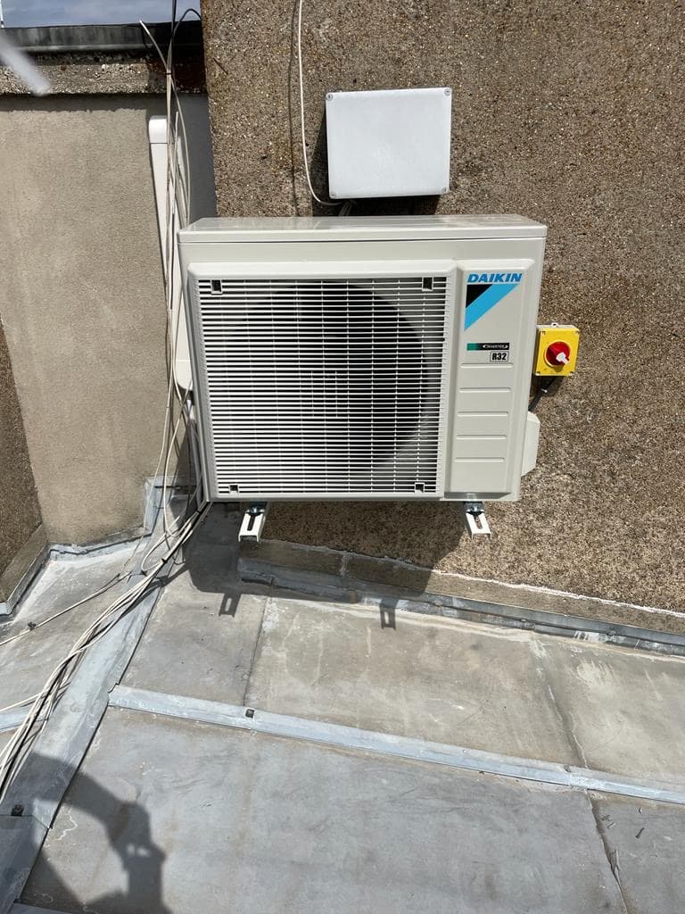 Unité extérieure Daikin fixée sur toiture terrasse avec coupe-circuit